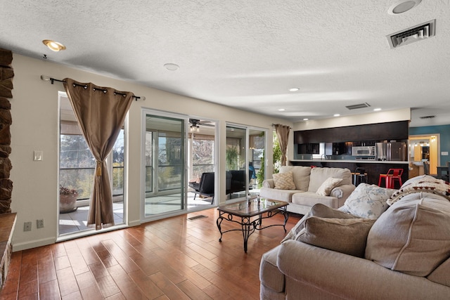 living room featuring wood-type flooring and a textured ceiling