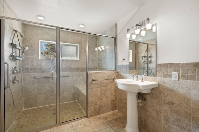 bathroom with tile walls, tile patterned floors, and a shower with shower door