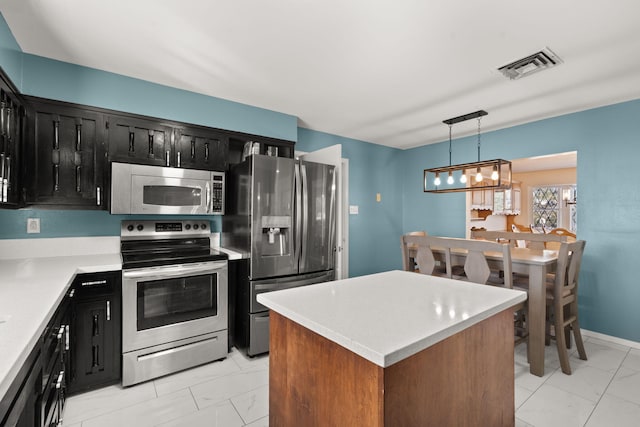 kitchen with pendant lighting, stainless steel appliances, and a kitchen island