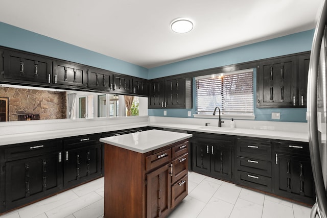 kitchen featuring a center island, sink, and stainless steel refrigerator