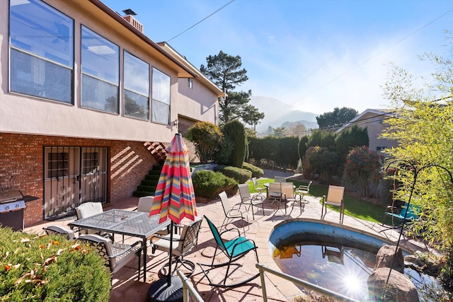 view of patio with a mountain view and grilling area