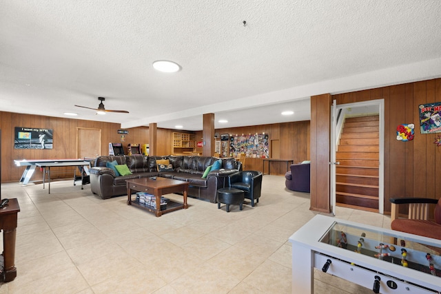 living room featuring billiards, a textured ceiling, and wood walls