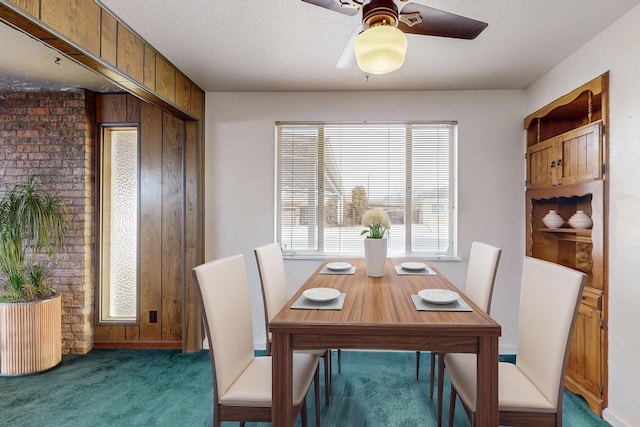 carpeted dining area featuring ceiling fan and a textured ceiling