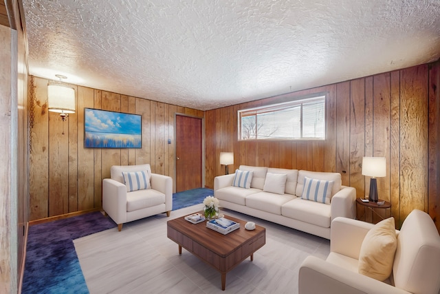 living room with a textured ceiling and wood walls