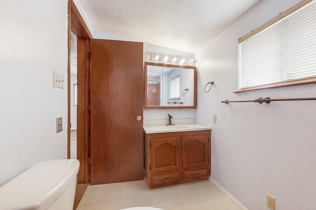 bathroom featuring lofted ceiling, vanity, toilet, tile patterned floors, and a textured ceiling