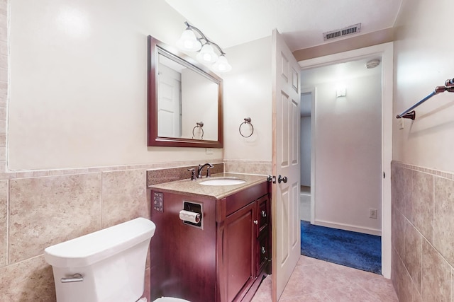 bathroom with tile patterned flooring, vanity, tile walls, and toilet