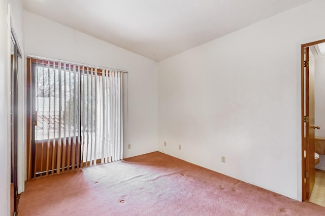 carpeted empty room with lofted ceiling