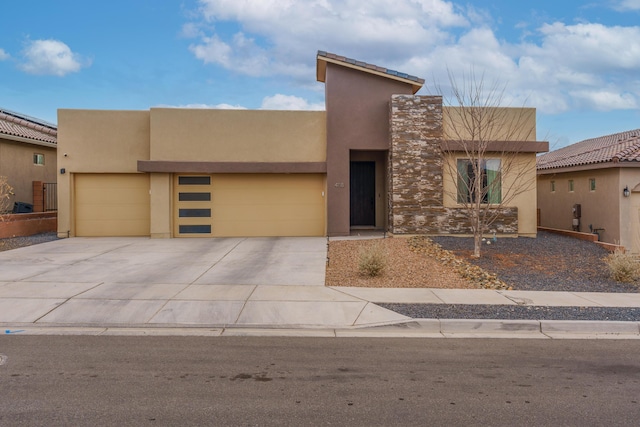 view of front of home featuring stone siding, stucco siding, an attached garage, and concrete driveway