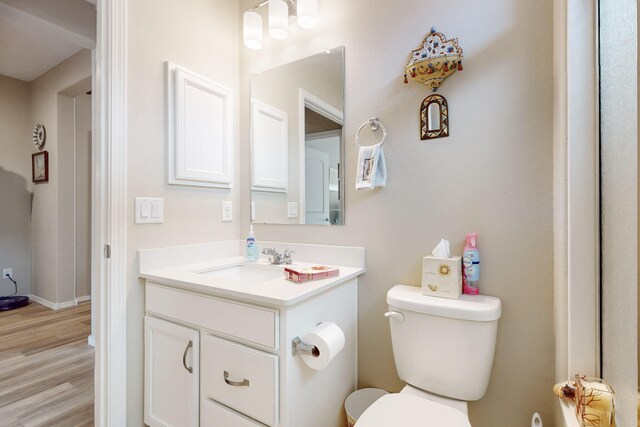 bathroom with hardwood / wood-style flooring, vanity, and toilet