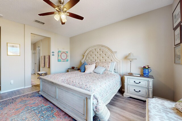 bedroom with dark wood-type flooring, a textured ceiling, and ceiling fan