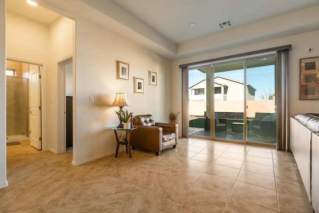 sitting room with light tile patterned floors, visible vents, and baseboards