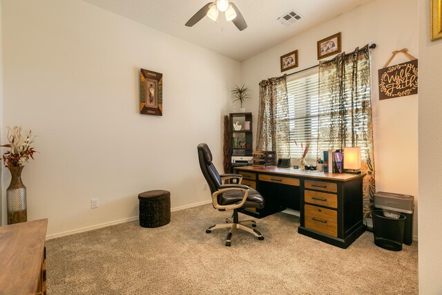 office featuring ceiling fan, visible vents, baseboards, and light colored carpet