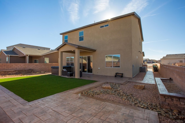 back of property with a yard, central air condition unit, stucco siding, a patio area, and a fenced backyard