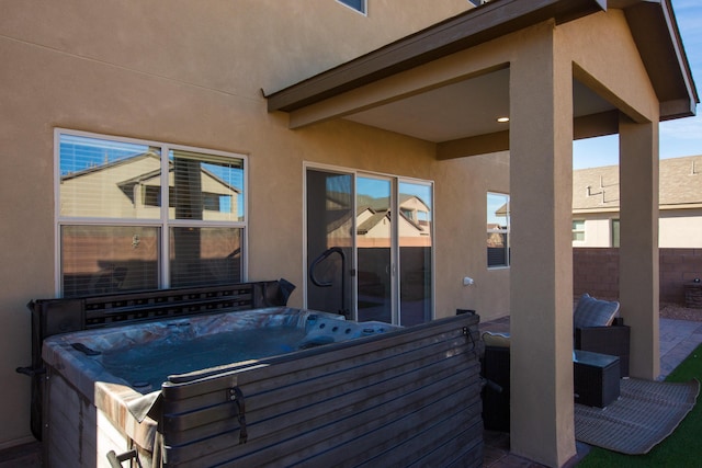 view of patio / terrace featuring fence and a hot tub