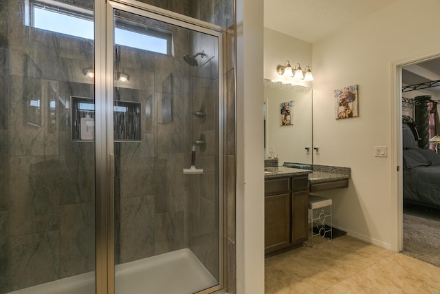 full bathroom featuring a stall shower, tile patterned flooring, vanity, and baseboards