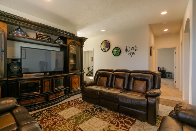 workout area featuring baseboards, visible vents, a textured ceiling, and carpet flooring