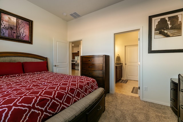 carpeted bedroom with visible vents, connected bathroom, and baseboards