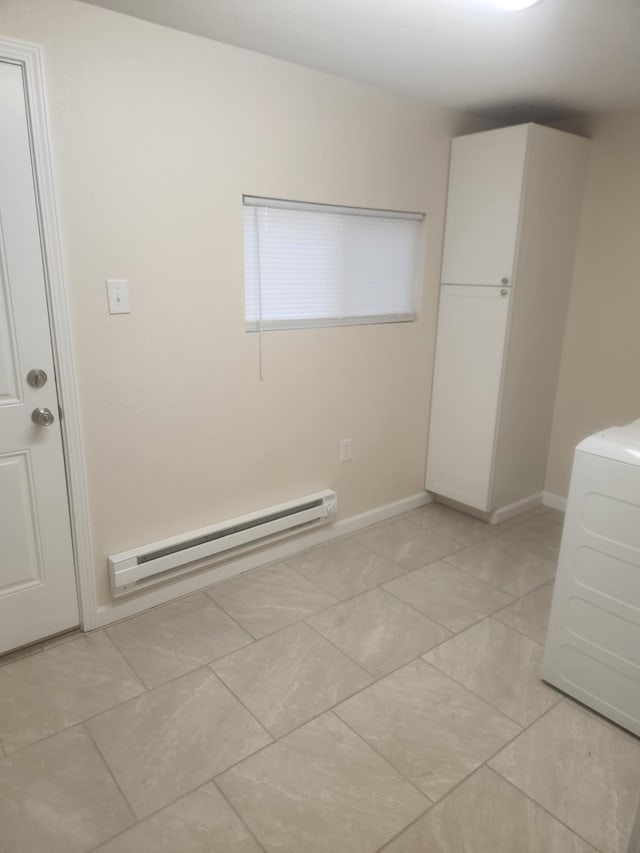 clothes washing area featuring washer / dryer and a baseboard heating unit