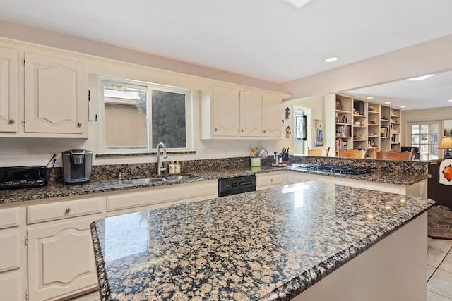 kitchen featuring sink, dark stone counters, and a center island