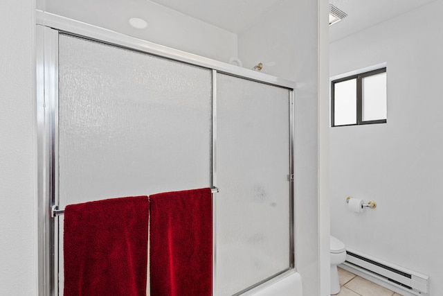 bathroom featuring bath / shower combo with glass door, tile patterned floors, toilet, and a baseboard heating unit