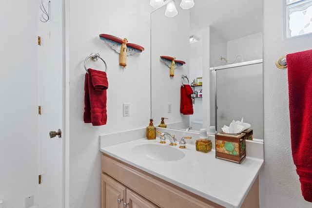 bathroom featuring vanity and a shower with shower door