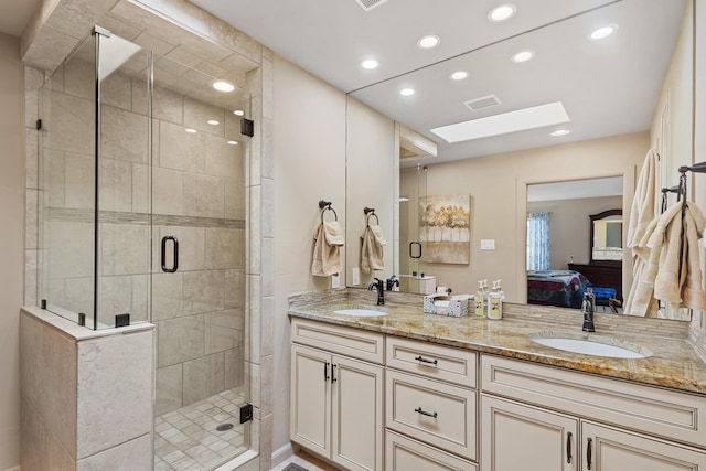 bathroom with vanity, a skylight, and a shower with shower door