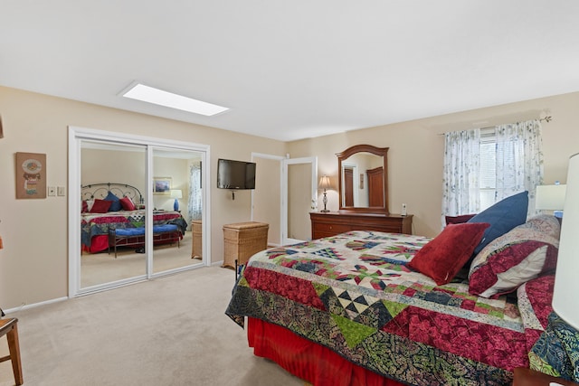 bedroom with a closet, carpet floors, and a skylight