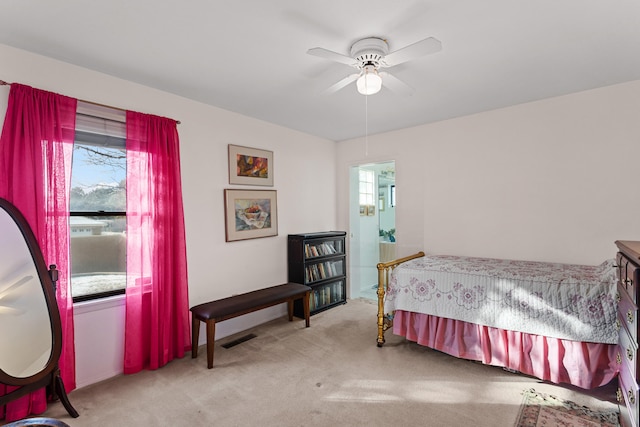 bedroom featuring ceiling fan, light carpet, and multiple windows