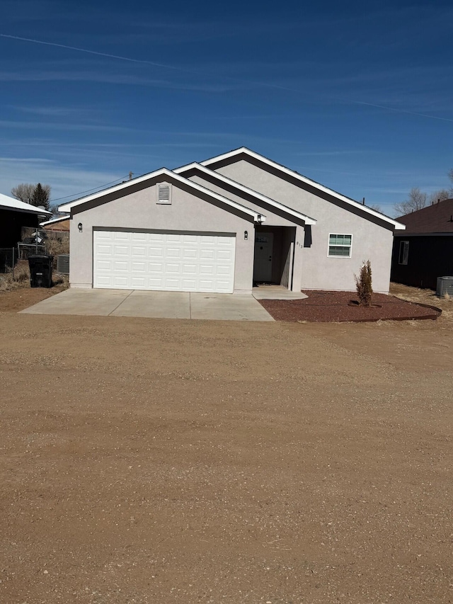 ranch-style house with stucco siding, driveway, and a garage