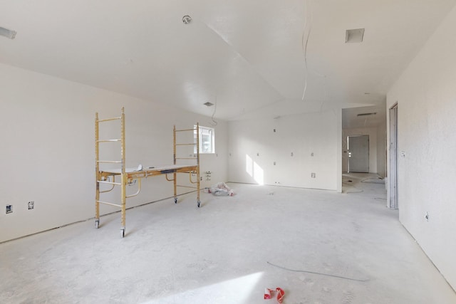 unfurnished room with vaulted ceiling