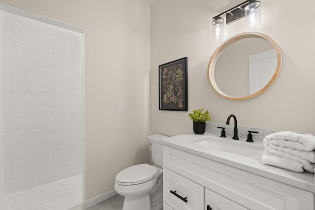 bathroom with vanity, toilet, and tiled shower