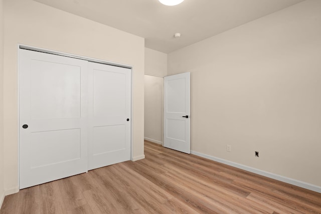 unfurnished bedroom with light hardwood / wood-style floors and a closet