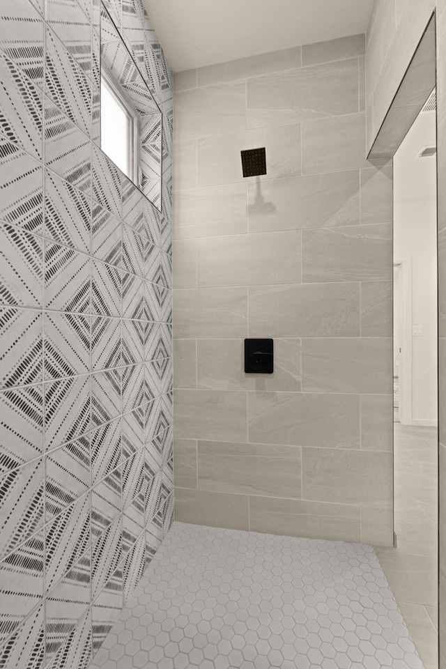 bathroom with tiled shower and tile patterned floors