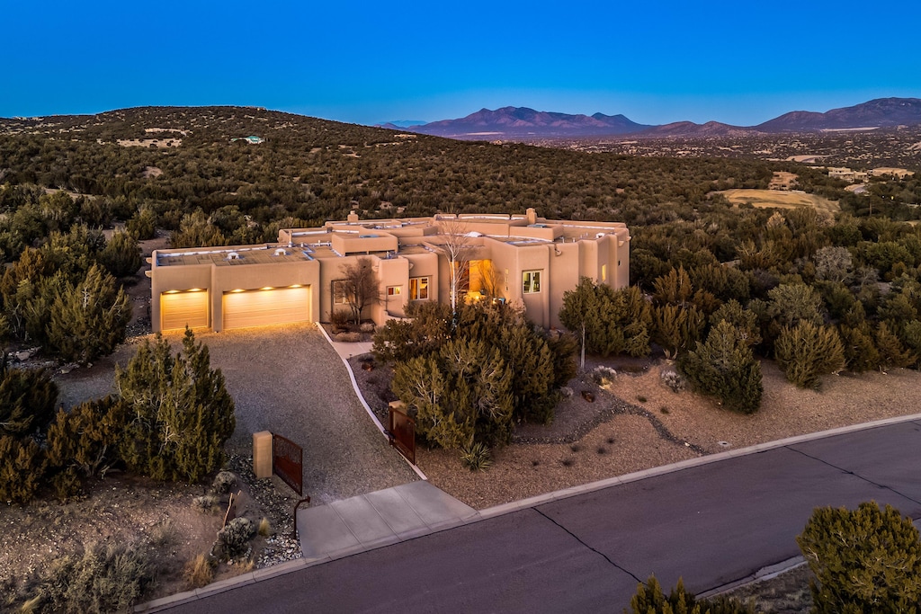 view of front of property with a mountain view, driveway, an attached garage, and stucco siding