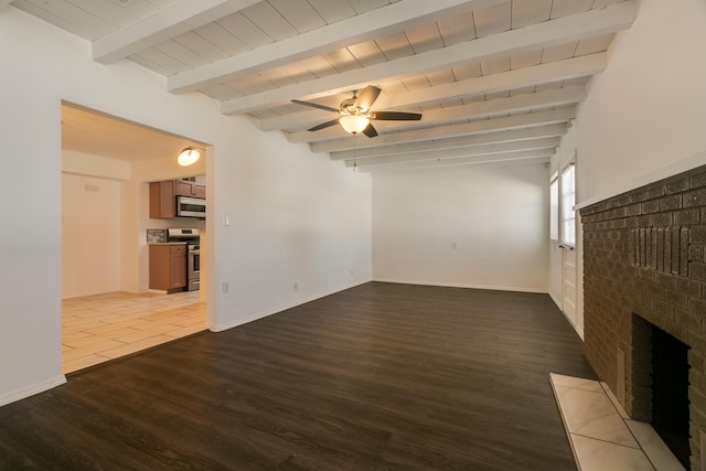 unfurnished living room featuring beamed ceiling, ceiling fan, a brick fireplace, and light hardwood / wood-style floors