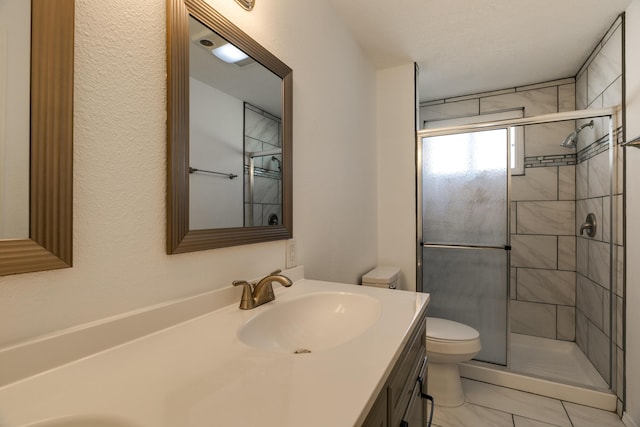 bathroom with vanity, toilet, and a shower with door