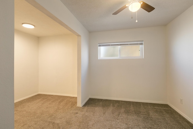 spare room featuring ceiling fan, carpet flooring, and a textured ceiling