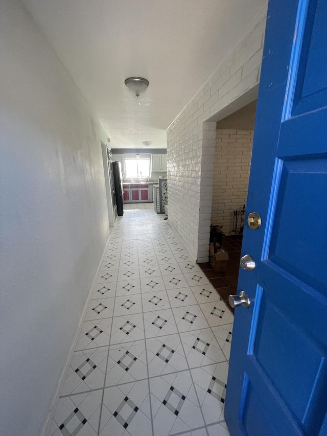 hallway with brick wall and baseboards