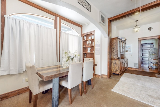 carpeted dining area with built in shelves