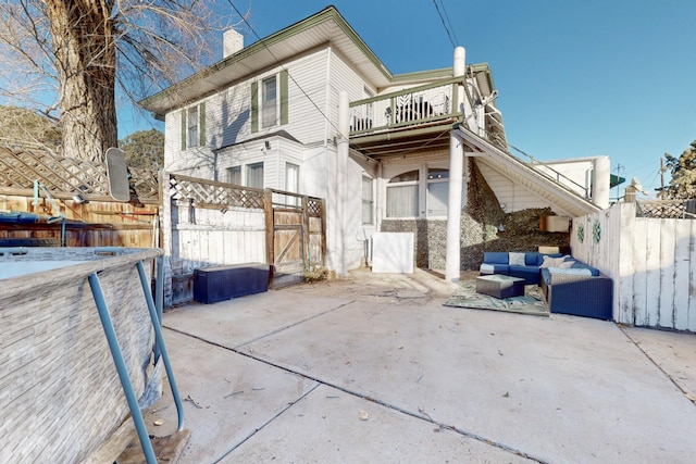 back of house featuring a balcony, outdoor lounge area, and a patio area