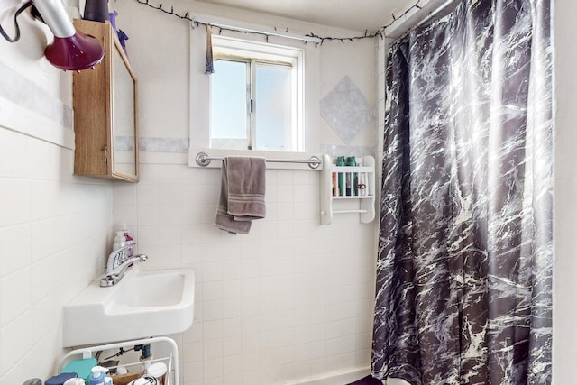 bathroom featuring sink, a shower with shower curtain, and tile walls