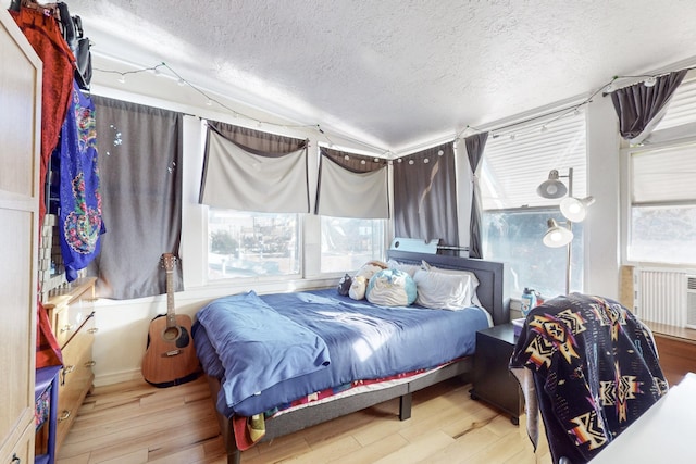 bedroom featuring hardwood / wood-style flooring and a textured ceiling