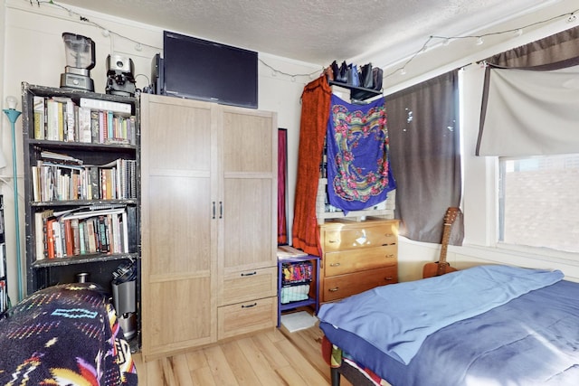 bedroom with hardwood / wood-style flooring and a textured ceiling