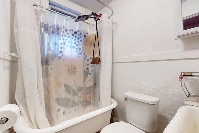 bathroom with toilet and shower / bath combo with shower curtain