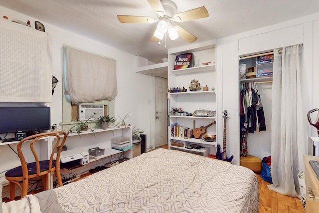 bedroom with cooling unit, hardwood / wood-style flooring, a closet, and ceiling fan