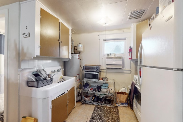 kitchen featuring white refrigerator, backsplash, and gas water heater