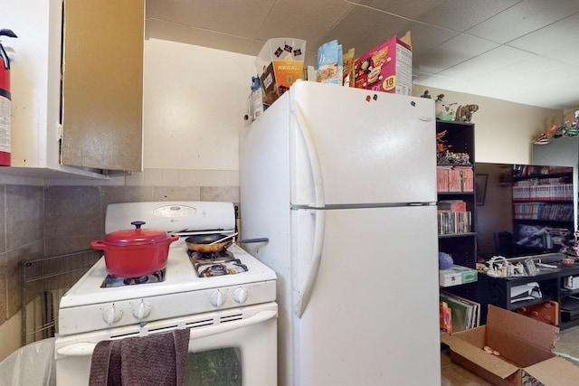 kitchen featuring white appliances and backsplash