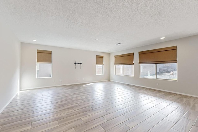 spare room with light hardwood / wood-style flooring and a textured ceiling