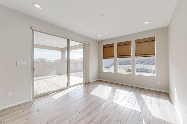 spare room with a wealth of natural light and light wood-type flooring