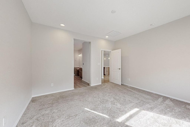 unfurnished bedroom with light colored carpet and ensuite bathroom